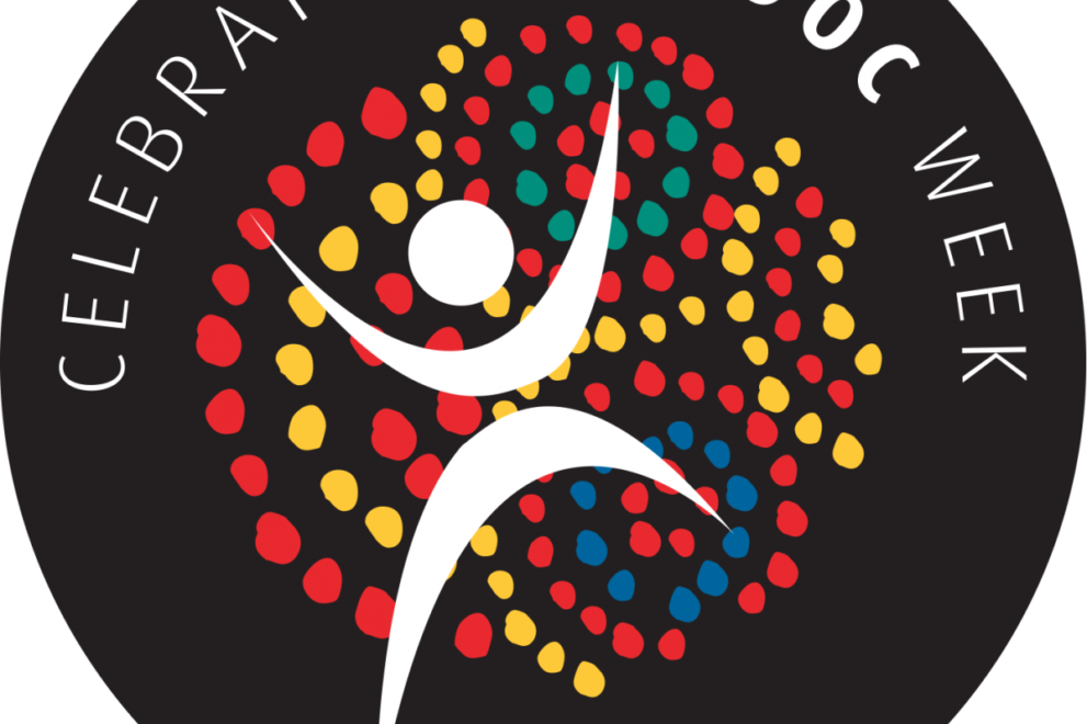 Logo for NAIDOC Week. A stylised white figure with arms raised appears in front of a circular dot design in red, yellow, green, and blue on a black background. Text around the circle reads: Celebrating NAIDOC Week.